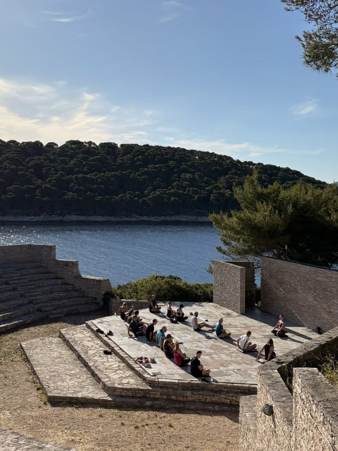 Yoga på stentrappor vid havet på den privata ön i Kroatien